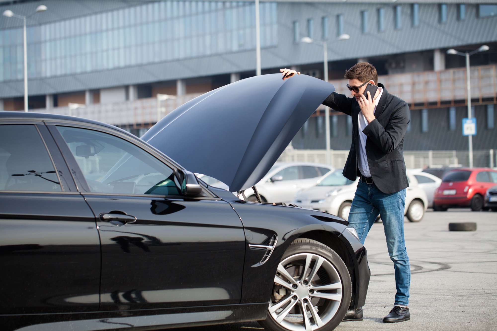 Man with broken car in the middle of the road